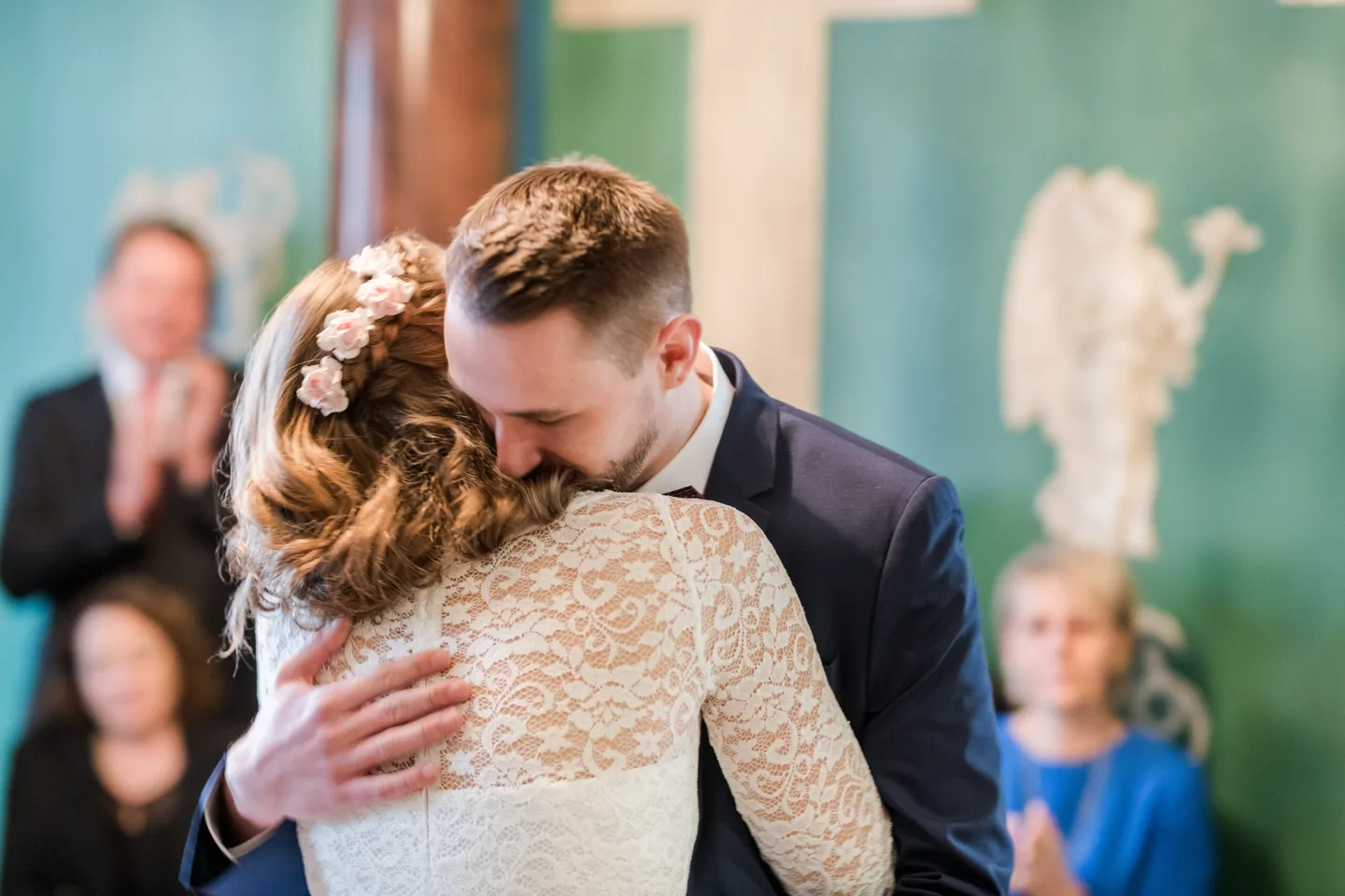 Bride and groom happily embrace in front of guests