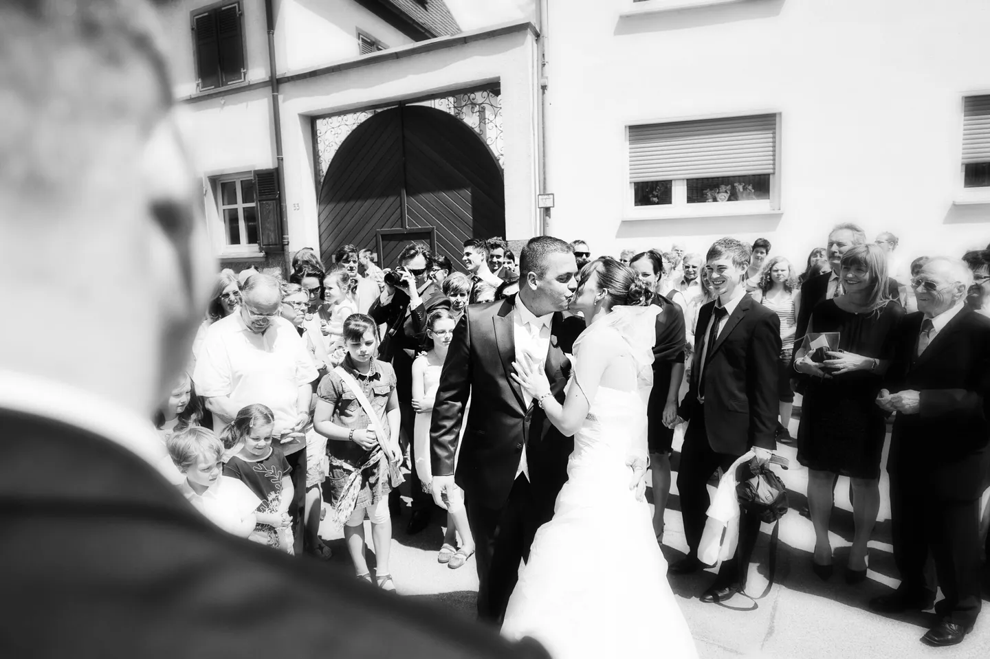 Wedding couple outdoors in front of guests, black and white