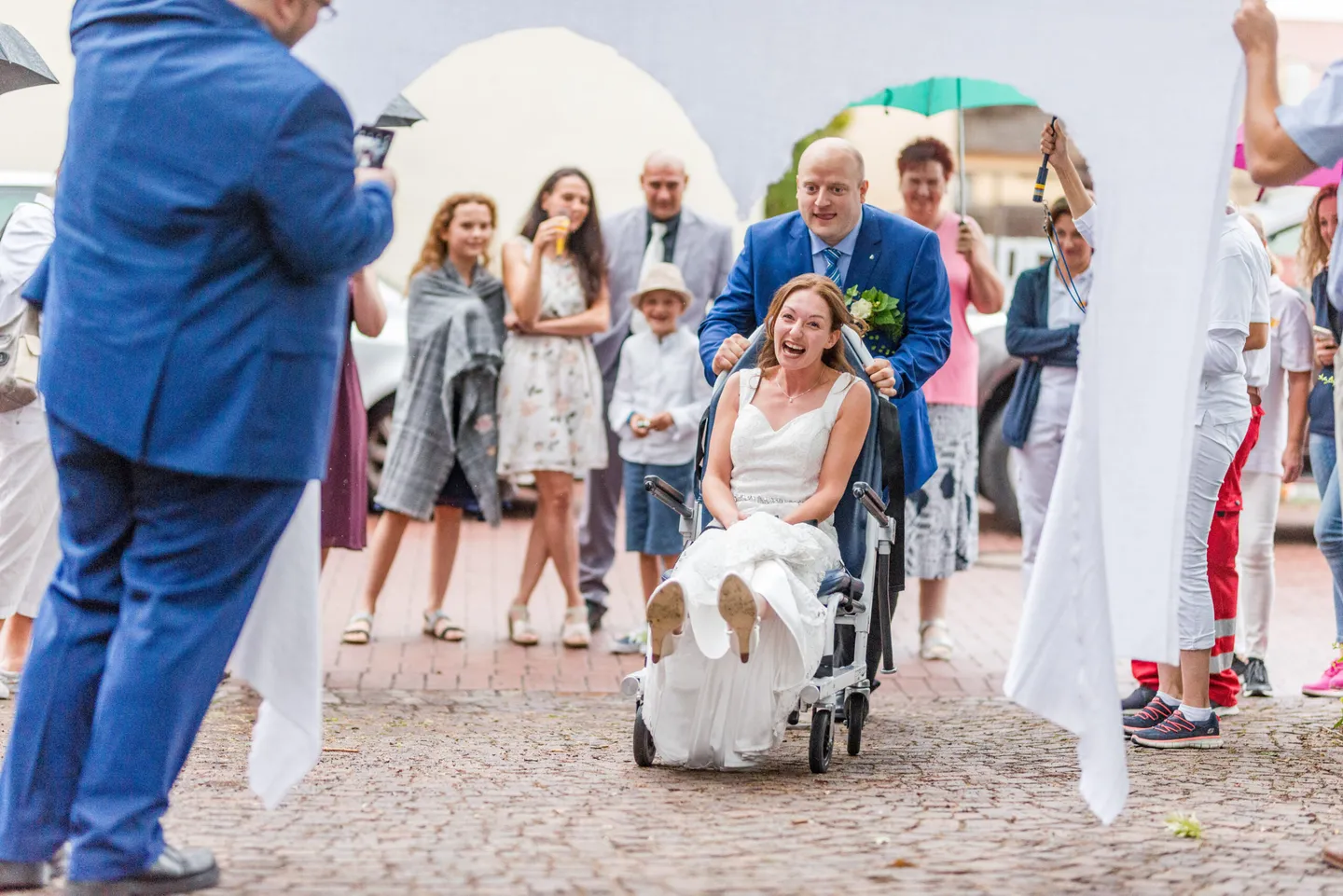 Laughing bride and groom at wedding game with wheelchair