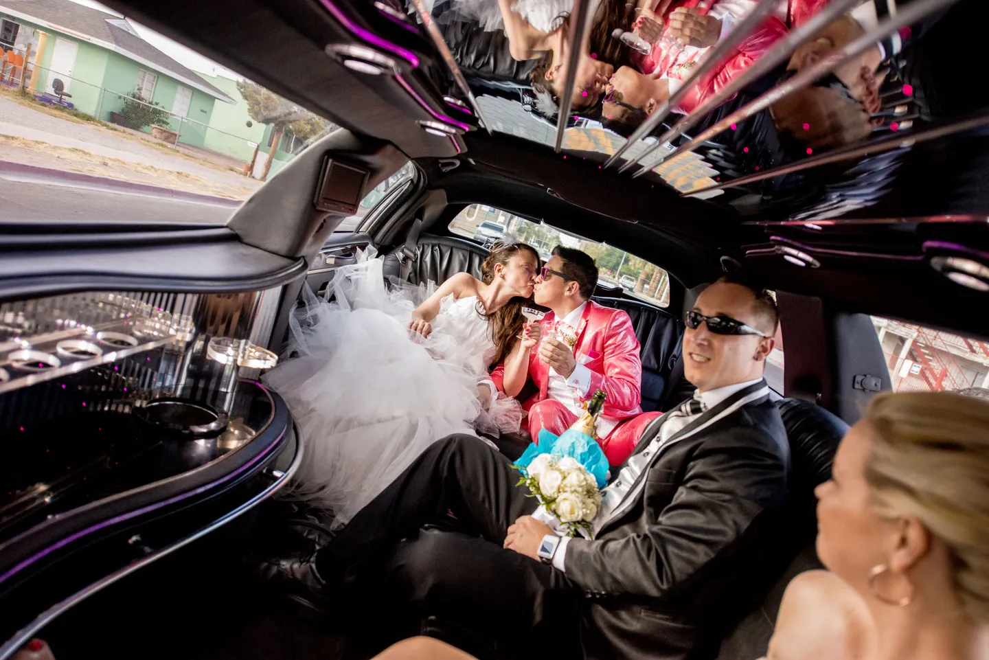 Bride and groom kissing in the limousine.