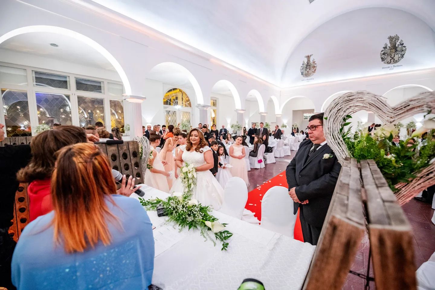 Wedding ceremony in a large hall with guests.