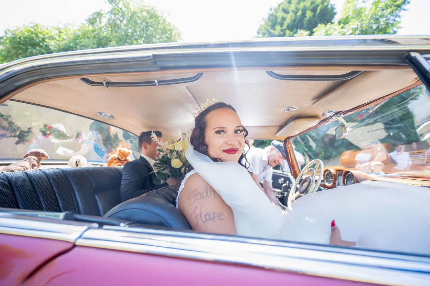 Bride in car with flowers and tattoo