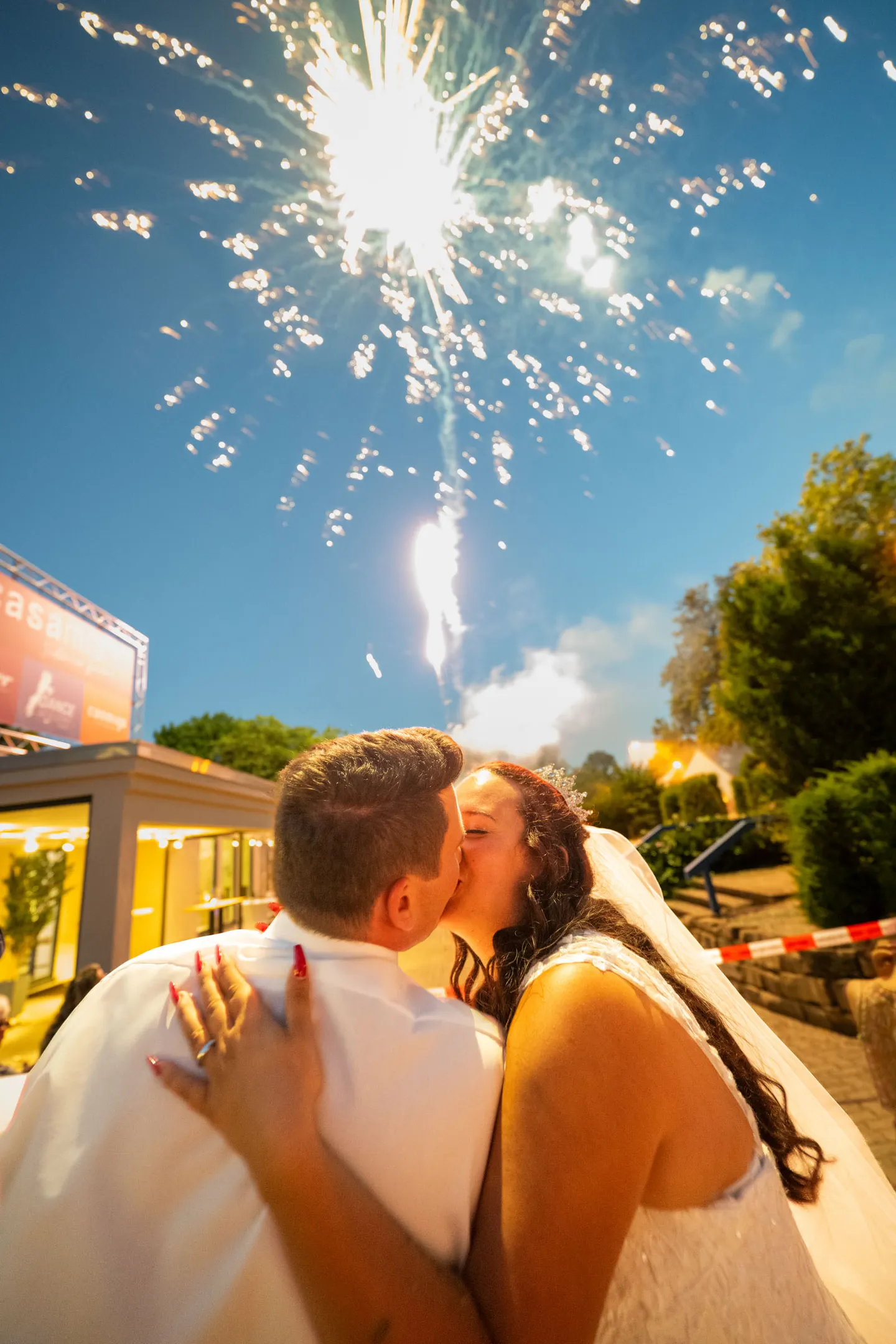 Wedding couple kissing under fireworks.