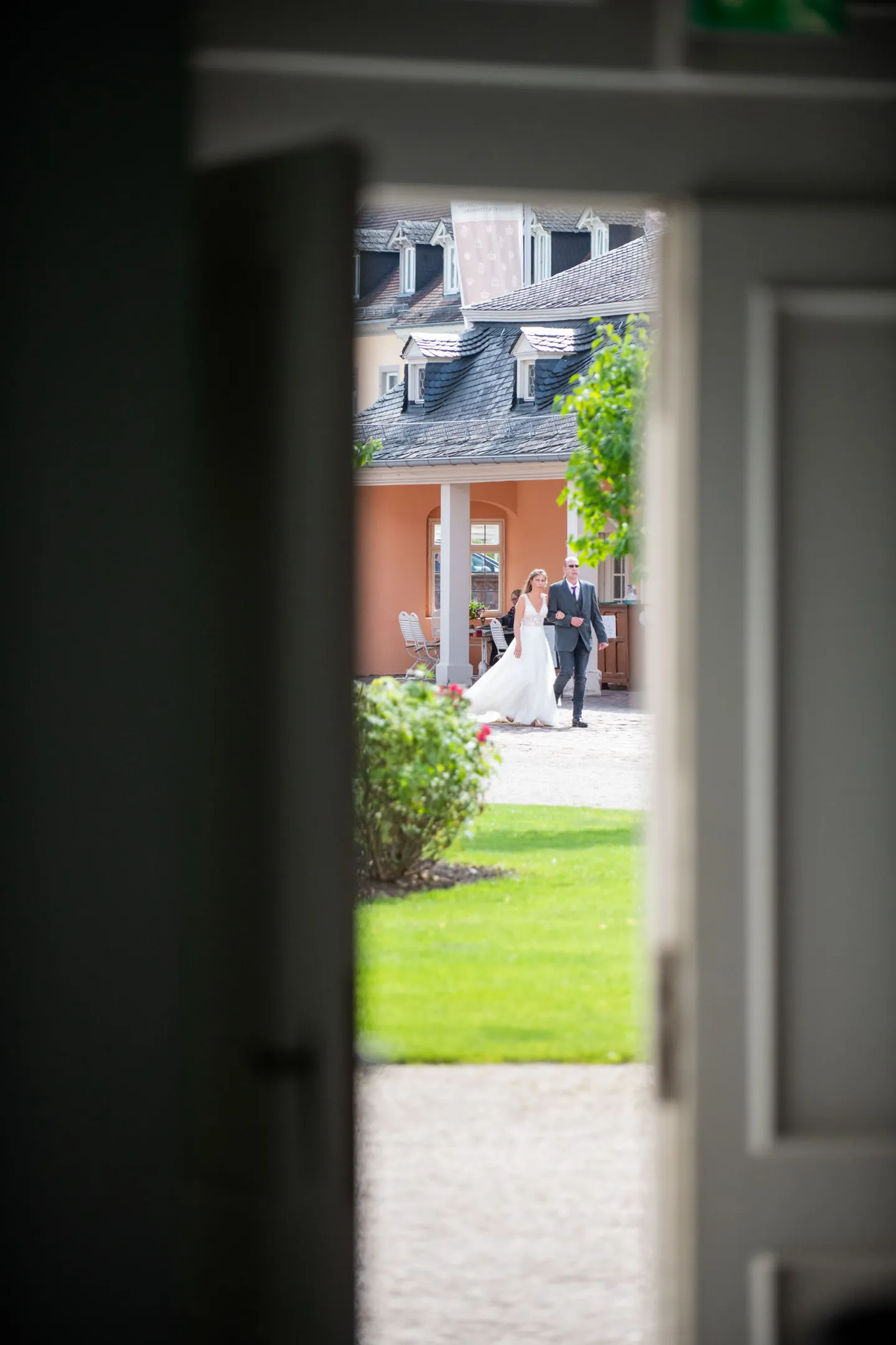 Bride and groom walk through door, summer wedding.