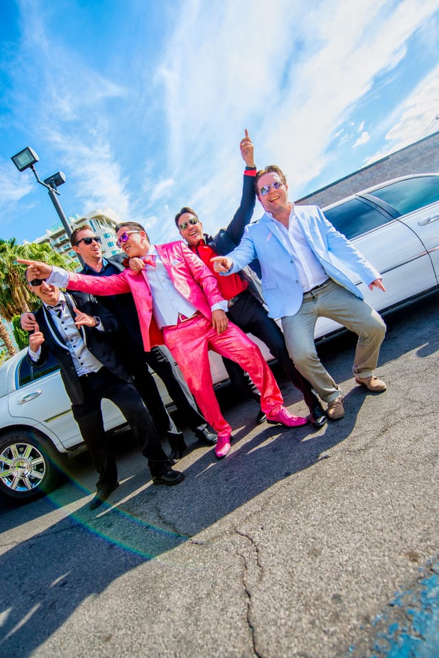 Men in suits in front of a limousine