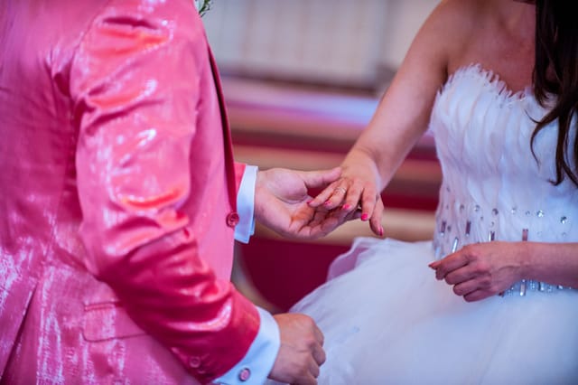 Bride and groom exchange rings at wedding