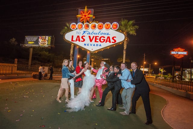Wedding couple in front of Las Vegas sign celebrating at night