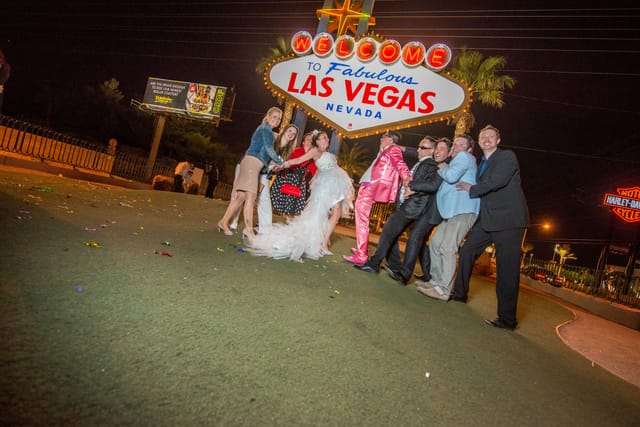 Group in front of Las Vegas sign at night