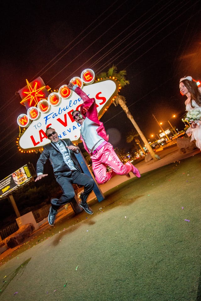 Jumping revelers in front of Las Vegas sign