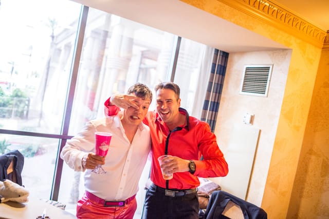 Two men celebrate with drinks.