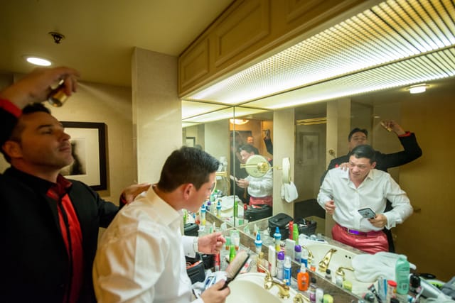 Men styling themselves in front of the bathroom mirror.