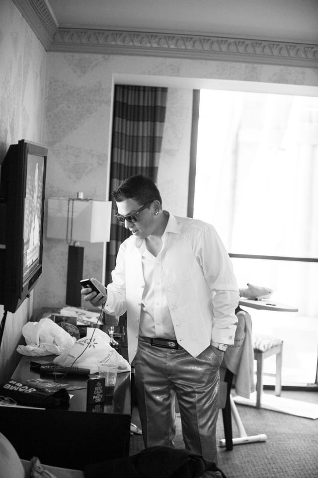Man in a suit checks his smartphone in his hotel room.