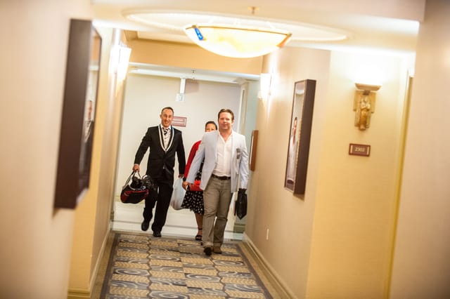 People walk in the hotel corridor with bags