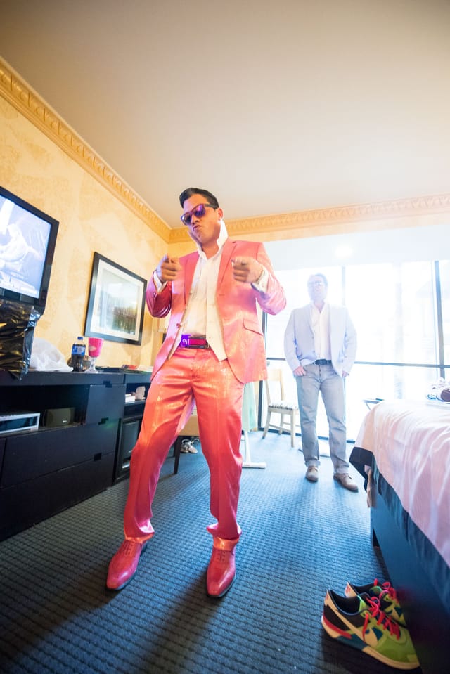 Man in a pink suit in a room.