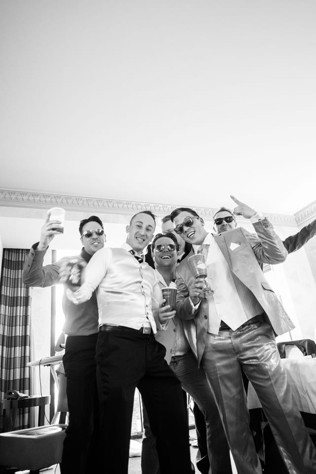 Group of men in suits celebrating happily.