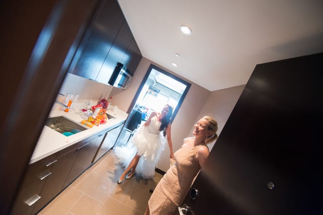 Two women in the kitchen, one wearing a wedding dress