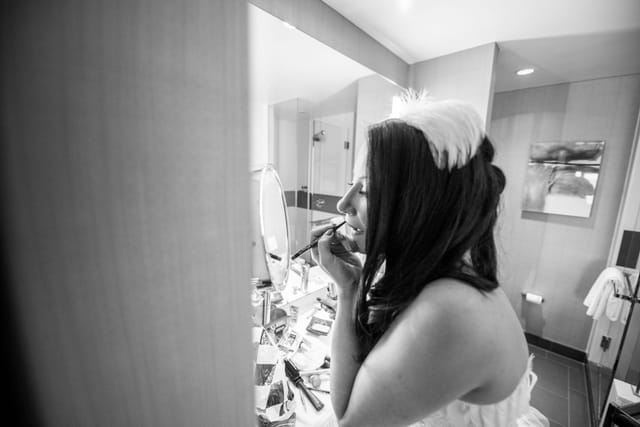 Woman applying make-up in the bathroom.