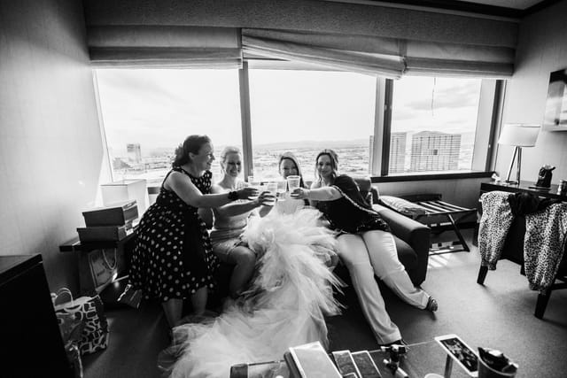 Women celebrate in hotel rooms with drinks.