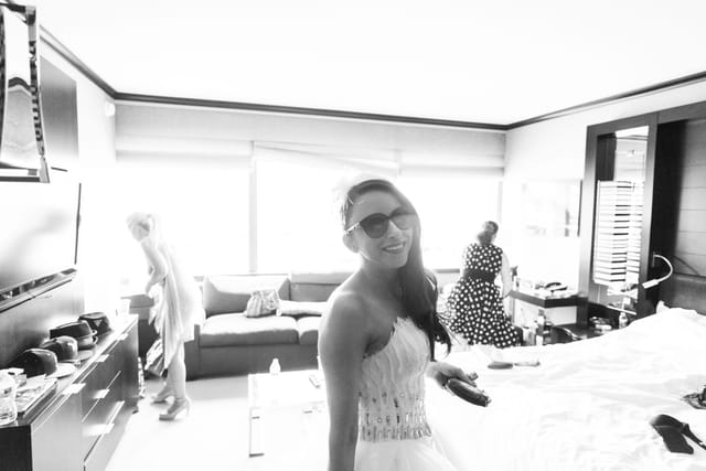 Smiling woman with sunglasses in a room.