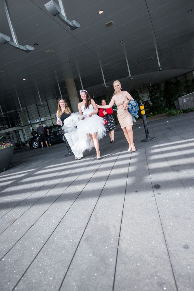 Laughing women in elegant dresses in front of a building.