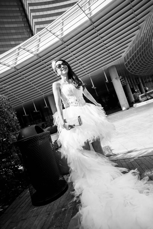 Woman in a white dress in front of a modern building