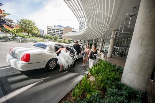 Bride gets into white limousine