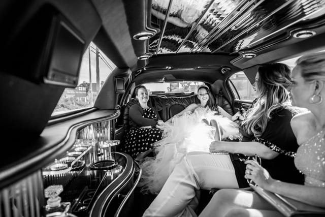 Women in a limousine, laughing and relaxed.