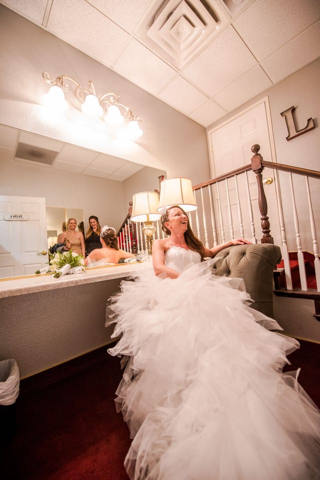Bride in white dress laughs in the dressing room